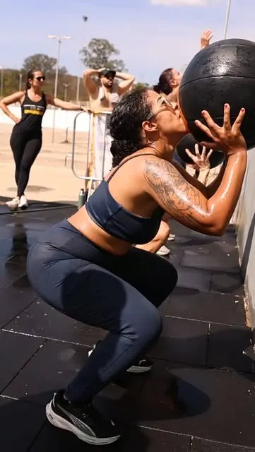 Aluna treinando com medicine ball